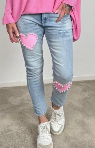 Stretchiga jeans i ljus tvätt med en rosa hjärtapplikation på bakfickan, dekorerad med glänsande pärlor. Finns i storlekar S-XL.