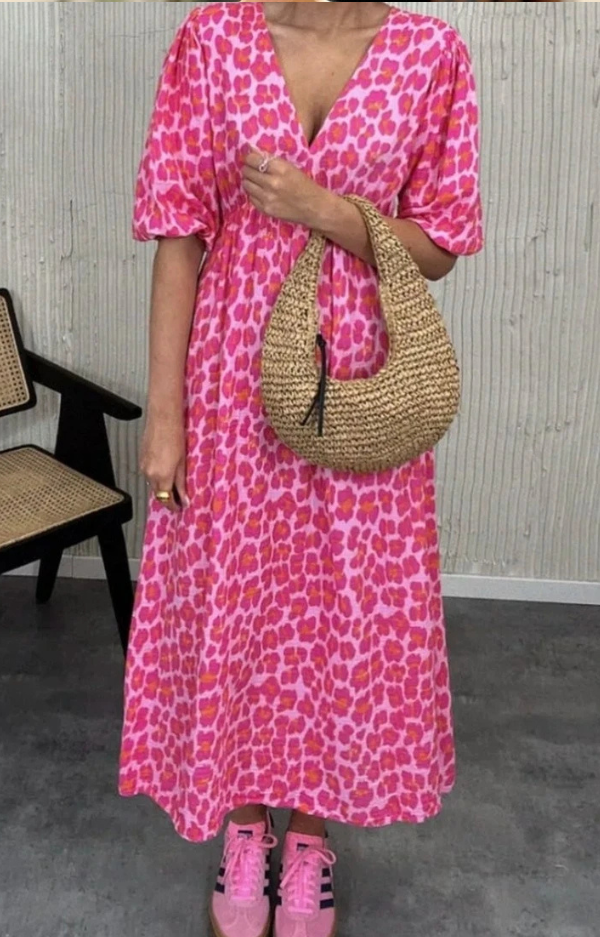 Klänning med rosa och cerise leopardprint i krinklad bomull, fotad utomhus i sommarljus. One size, luftig och feminin modell.