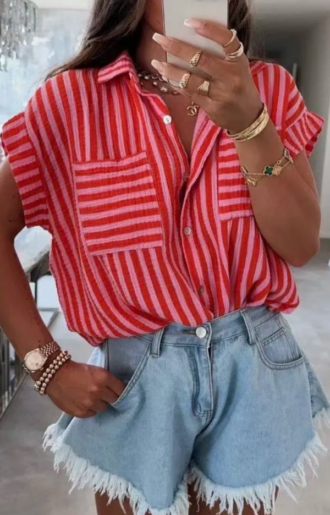 Kortärmad skjorta i rosa och rött, i krinklad bomull. Fotad på modell utomhus i sommarljus, matchad med jeansshorts.