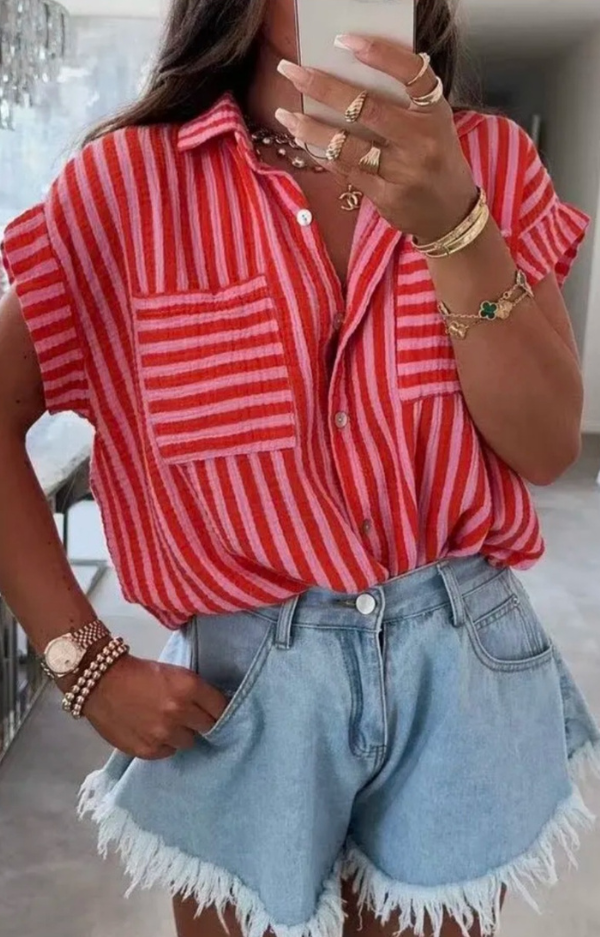 Kortärmad skjorta i rosa och rött, i krinklad bomull. Fotad på modell utomhus i sommarljus, matchad med jeansshorts.