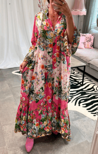 Bohemisk klänning i cerise med blommönster – 100% viskos, vidd i kjolen och volangärmar, passar storlek S till XL.