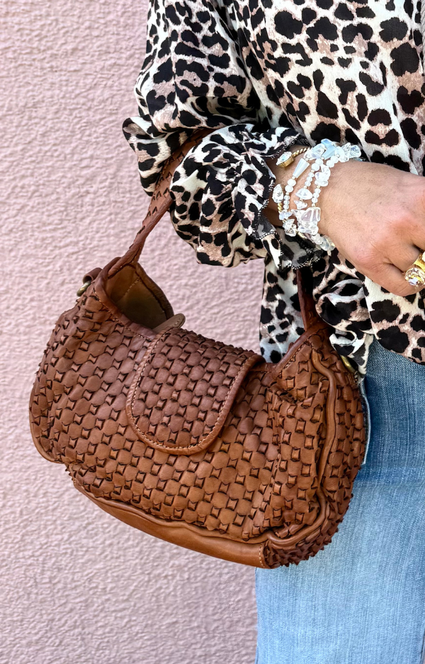 Mindre mörkbrun clutch/axelväska i flätat läder med handrem och axelrem – handgjord i Italien i boho luxe-stil.