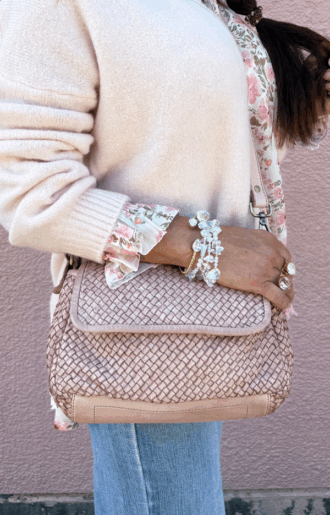 Handgjord väska i flätat läder med lock och avtagbar rem, Helen Väska i vintage-look med puderrosa innerfoder, fotad framifrån på neutral bakgrund.