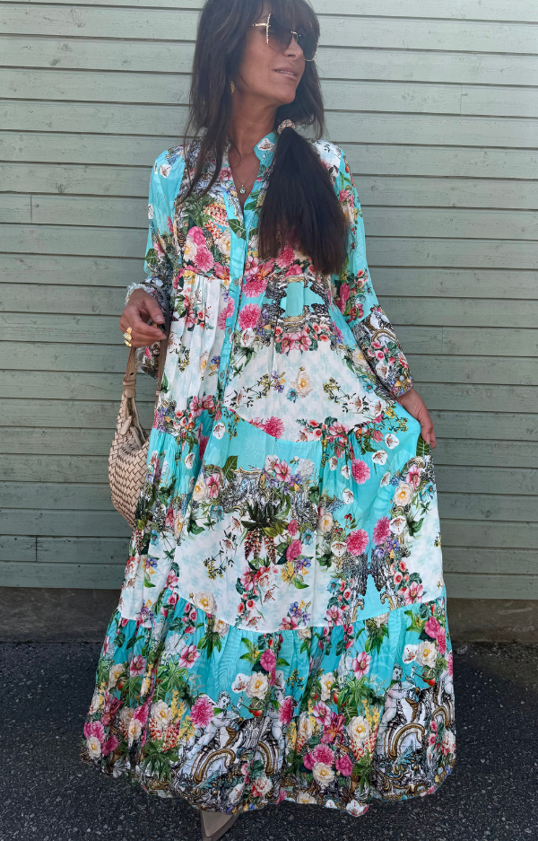 Turkos viskosklänning med blommor i rosa, blått, orange och grönt – luftig modell med volangärm och vidd i kjolen, passar S till XL