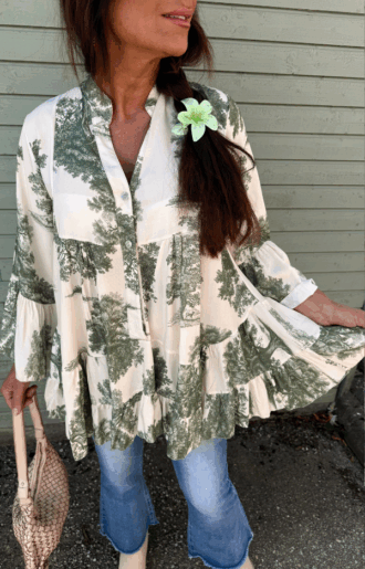 Bohemisk blus i offwhite viskos med armygrönt print och volanger, fotad framifrån med knäppning synlig.
