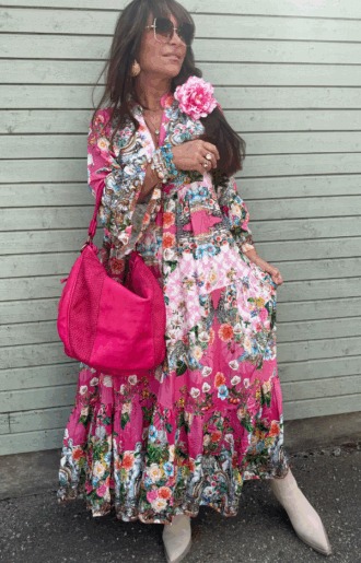 Bohemisk klänning i cerise med blommönster – 100% viskos, vidd i kjolen och volangärmar, passar storlek S till XL.