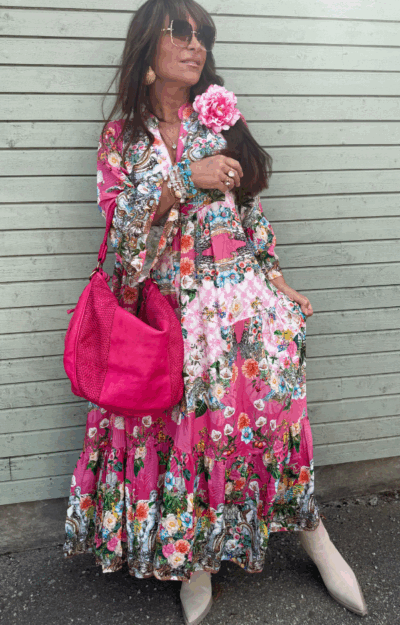 Bohemisk klänning i cerise med blommönster – 100% viskos, vidd i kjolen och volangärmar, passar storlek S till XL.