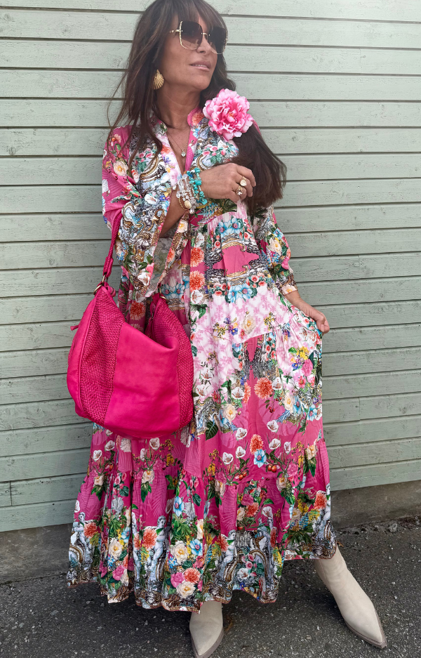 Bohemisk klänning i cerise med blommönster – 100% viskos, vidd i kjolen och volangärmar, passar storlek S till XL.