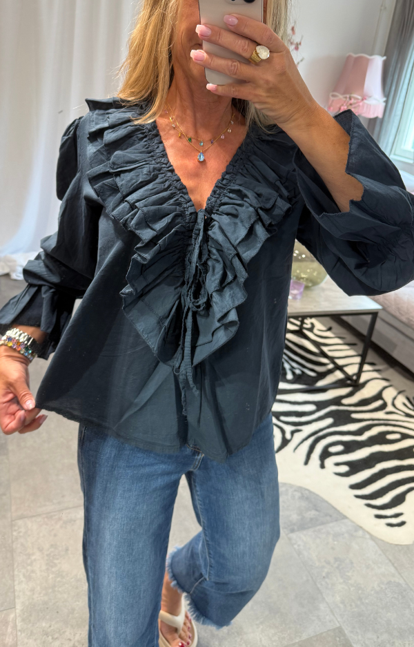 Navyblå bomullsblus med puffärmar, volanger och djup V-ringning med knyt. 100 % bomull. Bohochic design i S–M och L–XL.