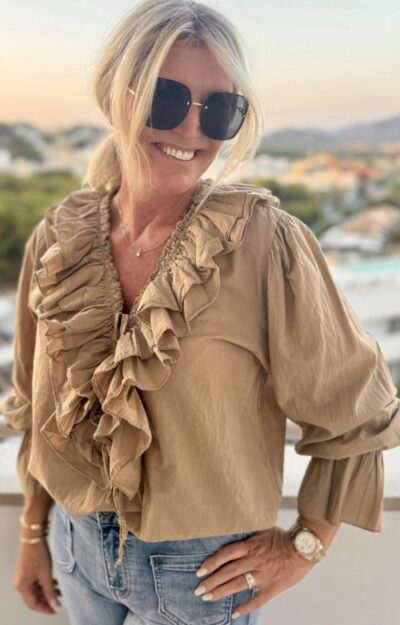 Camel-färgad blus i bomull med puffärmar, volanger och knytband – bohochic stil på modell.