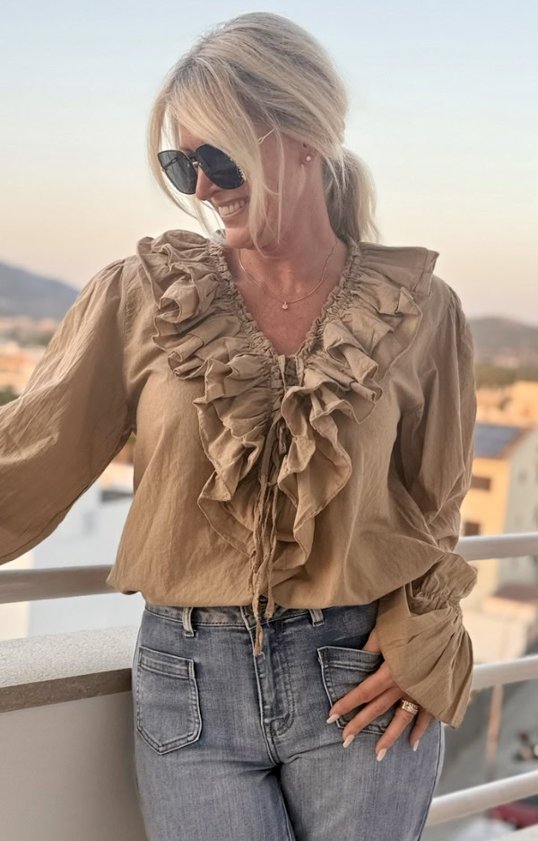 Camel-färgad blus i bomull med puffärmar, volanger och knytband – bohochic stil på modell.