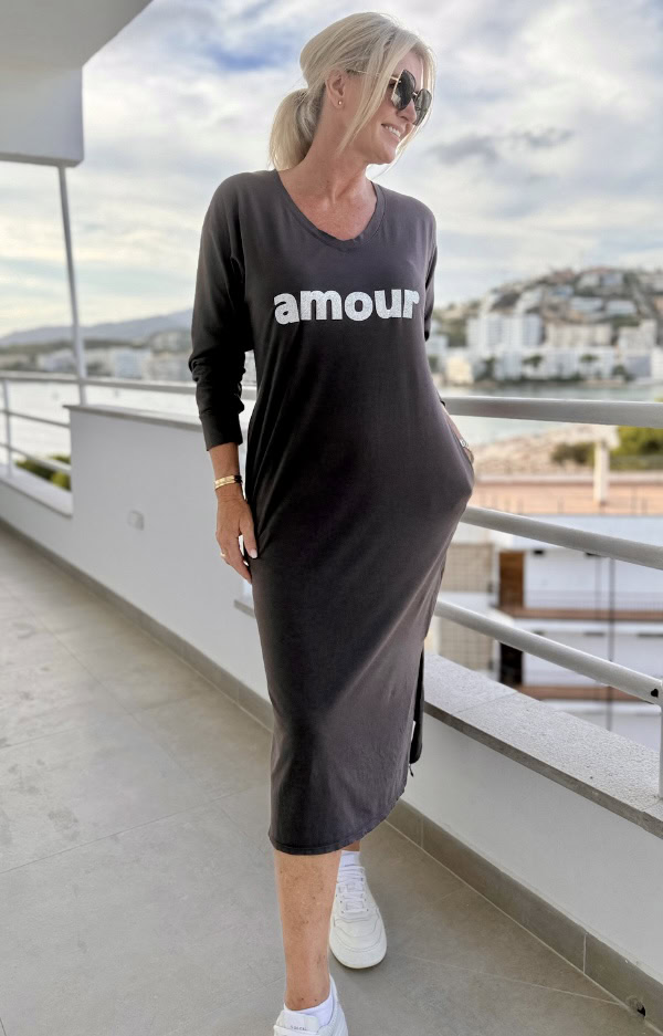 T-shirtklänning i färgen almost black med glittrigt Amour-tryck, v-ringning, sidofickor och slitsar. Rak passform i stretchig bomull.