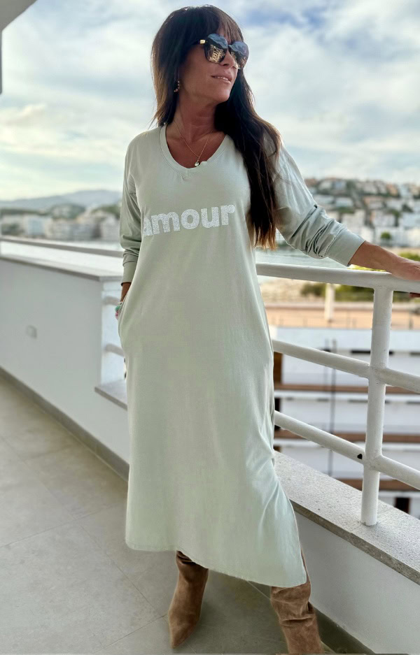 Olivgrön t-shirtklänning i bomull med glittrigt "Amour"-tryck, v-ringning, fickor och slitsar nertill. Rak passform i stretchigt tyg.