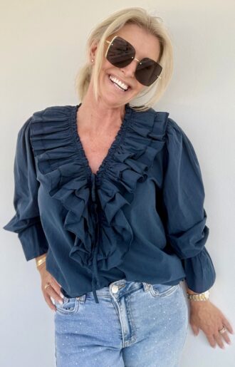 Navyblå bomullsblus med puffärmar, volanger och djup V-ringning med knyt. 100 % bomull. Bohochic design i S–M och L–XL.