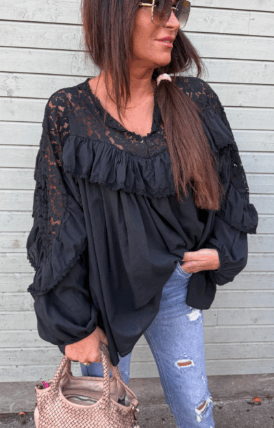 Magisk svart blus i mjuk bomullsvoile med spets och volanger. Bohemisk och feminin modell One Size XS–XL – lika fin till jeans som till kjol.