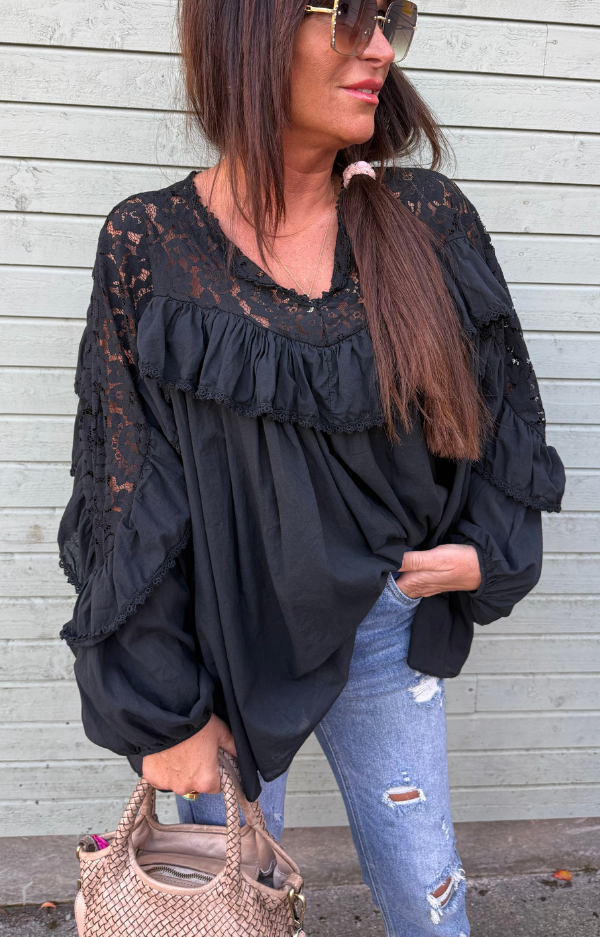 Magisk svart blus i mjuk bomullsvoile med spets och volanger. Bohemisk och feminin modell One Size XS–XL – lika fin till jeans som till kjol.