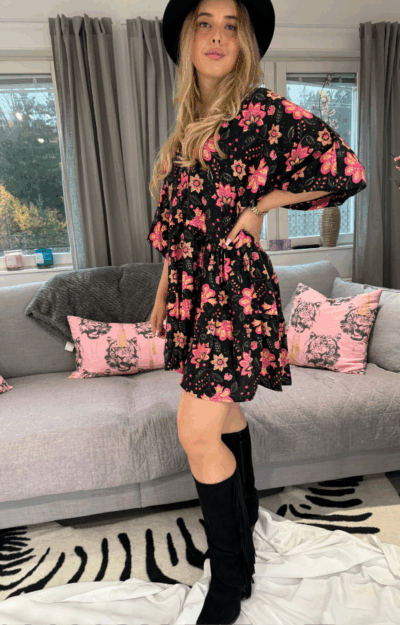 Bohemisk tunika i 100% viskos med svart botten och rosa blommor – V-ringad hals, ballongärmar och volanger.