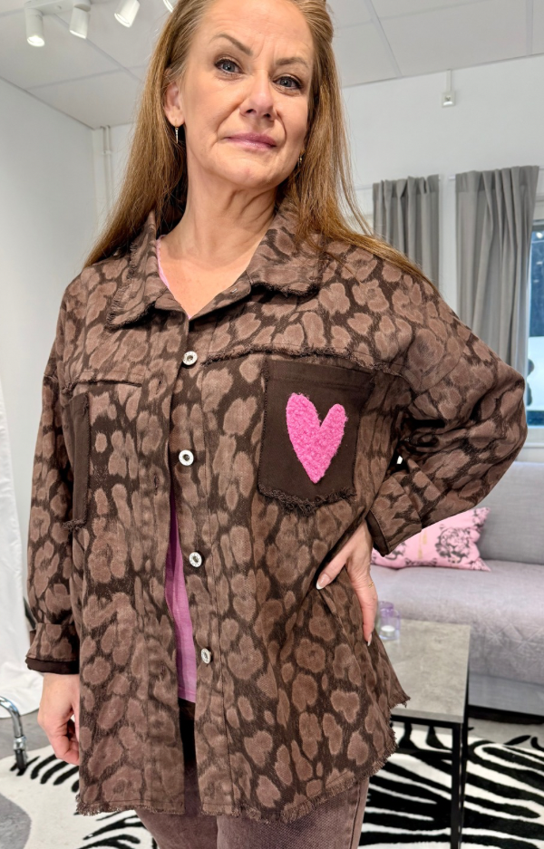 Untitled design Chokladbrun leopardmönstrad overshirt i bomull med rosa hjärta på bröstficka. Trendig jacka med råa kanter och lös passform ca 72 cm.