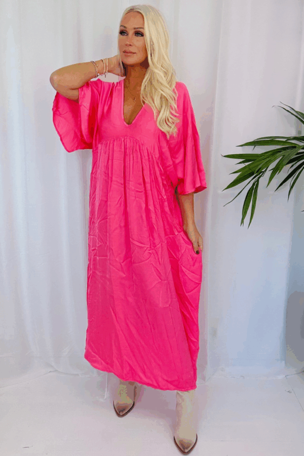 Corallrosa klänning i viskos med satinliknande glans, v-ringning och luftig passform, one size XS–XL.