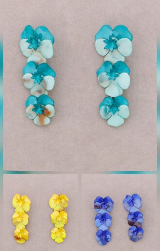 Färgglada örhängen med resinblommor – tre blommor i rad i nyanserna turkos, gul och blå. Längd på 8 cm och vikt 50 g, vilket ger ett tydligt statement och en lekfull, bohemisk känsla. Perfekta för att addera färg och personlighet till din outfit – bär dem till enkla toppar, klänningar eller koordinerade färger i garderoben. Ett smycke som syns och lyfter hela looken.