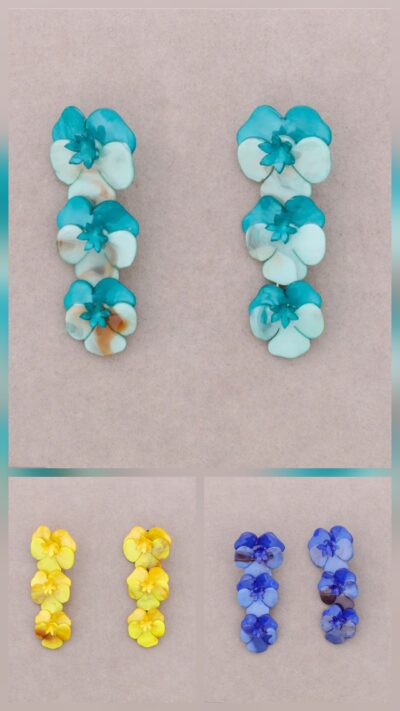 Färgglada örhängen med resinblommor – tre blommor i rad i nyanserna turkos, gul och blå. Längd på 8 cm och vikt 50 g, vilket ger ett tydligt statement och en lekfull, bohemisk känsla. Perfekta för att addera färg och personlighet till din outfit – bär dem till enkla toppar, klänningar eller koordinerade färger i garderoben. Ett smycke som syns och lyfter hela looken.