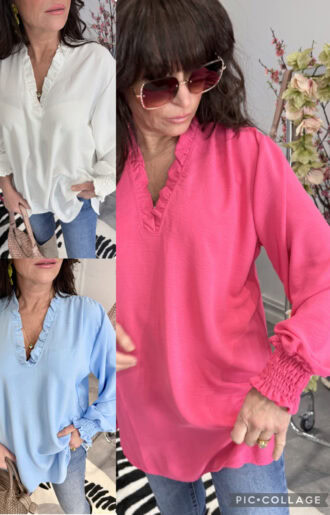 Supersöt blus med bred smock vid ärmslut och v-ringad hals med volang, normal passform, på modell.