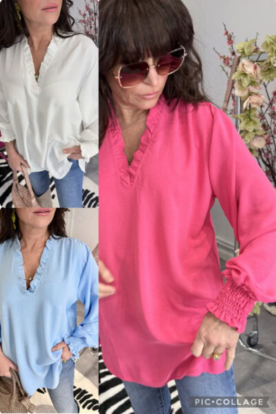 Supersöt blus med bred smock vid ärmslut och v-ringad hals med volang, normal passform, på modell.