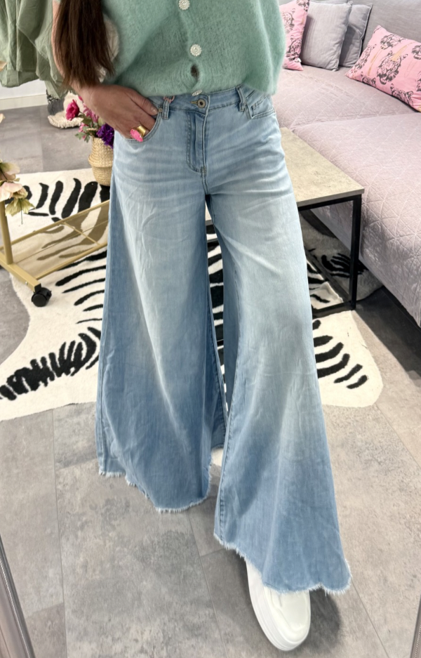 Utsvängda jeans i mjuk stretchig denim med rå kant nedtill och vid passform från knät.