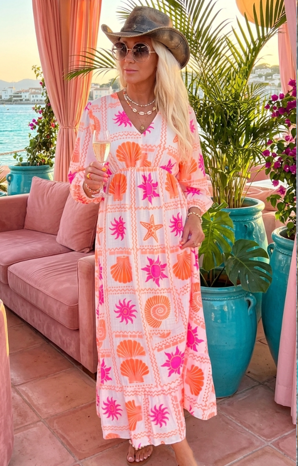 Sommarklänning med vit botten och rosa & orange print med snäckor och solar på modell, smickrande passform med resår och justerbart nackband.