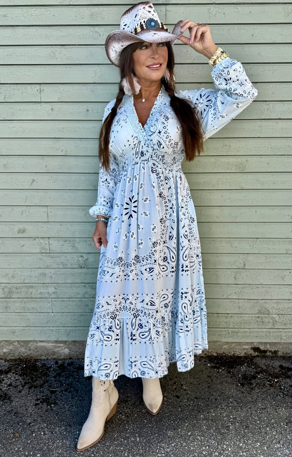 Ljusblå klänning i 100% viskos med scarfprint i bandanamönster, smock under byst, fickor i sidorna och feminin boho chic-passform.