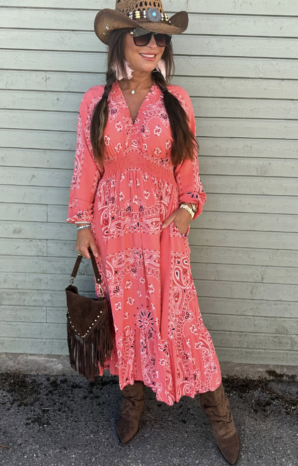 Korallröd klänning i 100% viskos med scarfprint i bandanamönster, smock under byst, fickor i sidorna och feminin boho chic-passform.