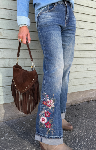 Blå jeans med rak passform, hög midja och vackra blombroderier på båda benen. Stretchiga damjeans från Love Forever med feminin westerninspirerad stil.