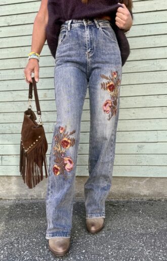 Blå-grå jeans med rak passform, hög midja och vackra blombroderier på båda benen. Stretchiga damjeans från Love Forever med feminin westerninspirerad stil.